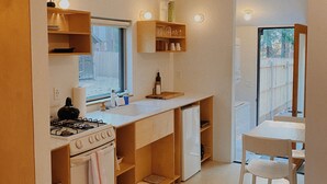 A compact kitchen with a gas stove, a sink, and a window overlooking a street. - The Place Beyond The Pines - Two Bedroom  / C6 (Big Bear Lake)