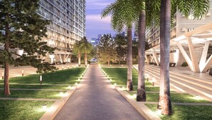 Un sendero bordeado por palmeras y edificios modernos que conduce a un edificio de diseño arquitectónico único.