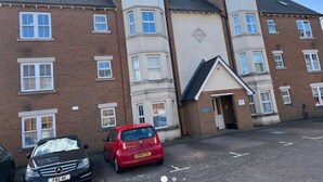 A multi-story building with a parking area in front. - Central location 2-Bed Apartment in Maidstone (Maidstone)