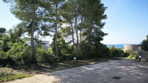 A paved pathway leading to a stone building with a view of the sea. - Apartment Giove by Interhome (Torre Vado)