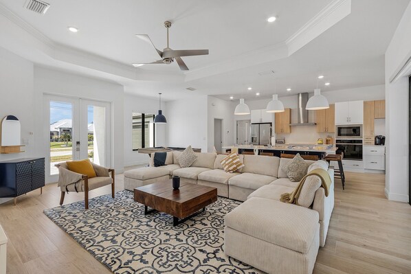 A spacious living room with a large sofa, a coffee table, and a patterned rug.