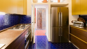 Una cocina equipada con un refrigerador de acero inoxidable, estufa y tostadora.