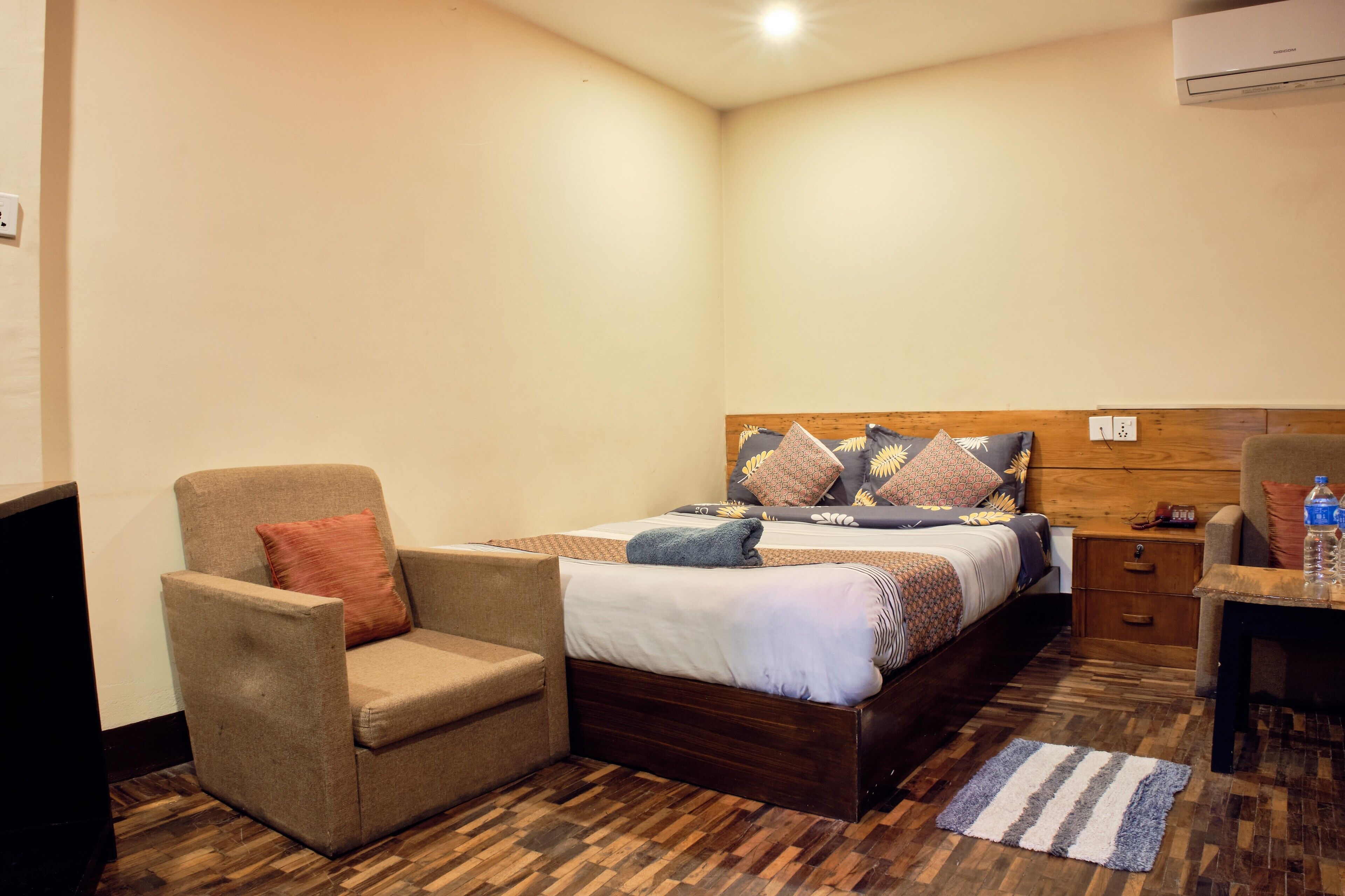 A bedroom with a bed, a chair, a nightstand, and a desk.