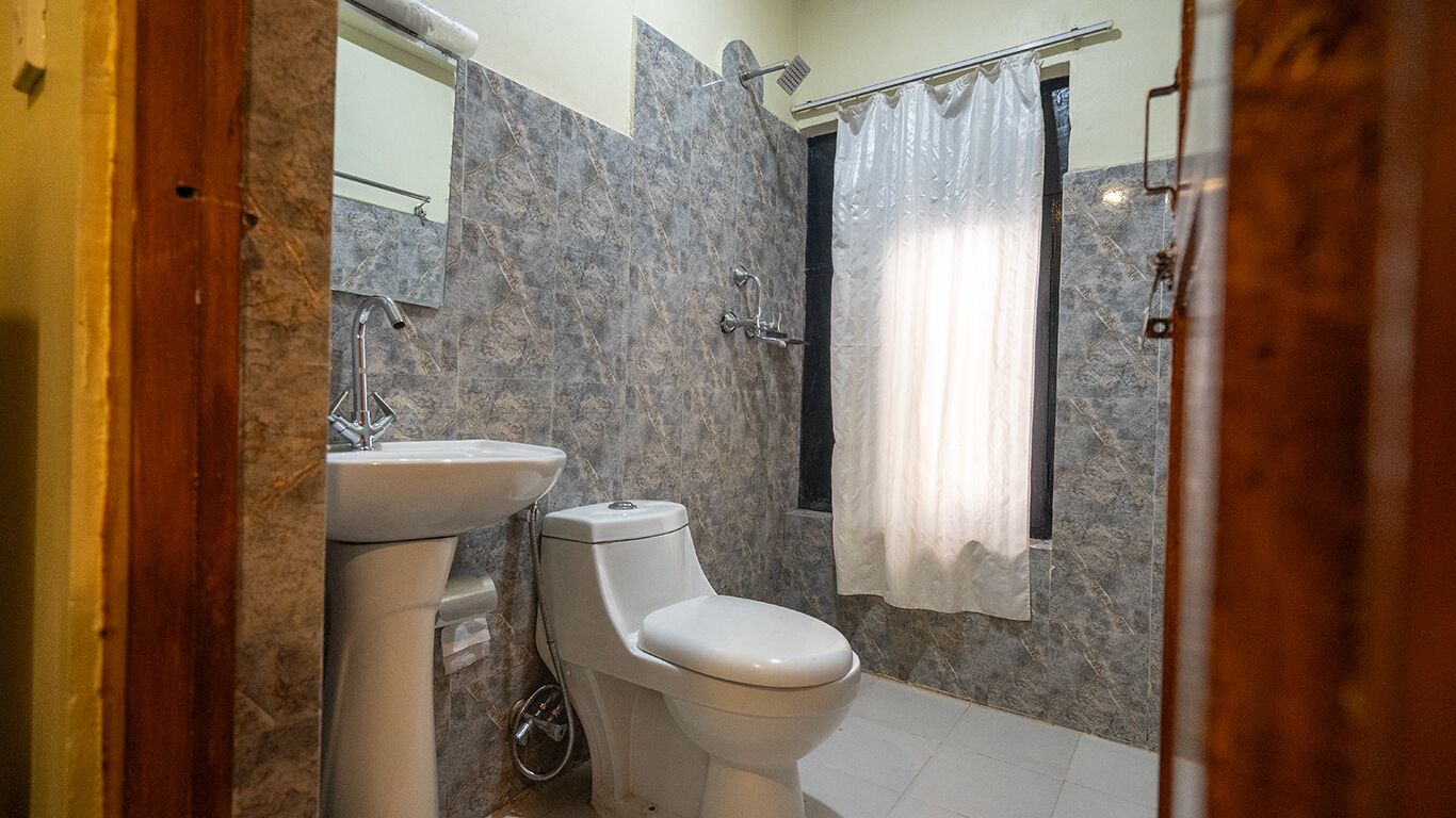 Een badkamer met toilet, wastafel en douchegordijn.