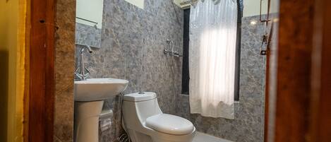 A bathroom with a toilet, sink, and shower curtain.