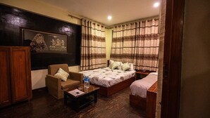 A room with a bed, a chair, a small table, and a cabinet. - Hotel Shree Tara (Kathmandu)