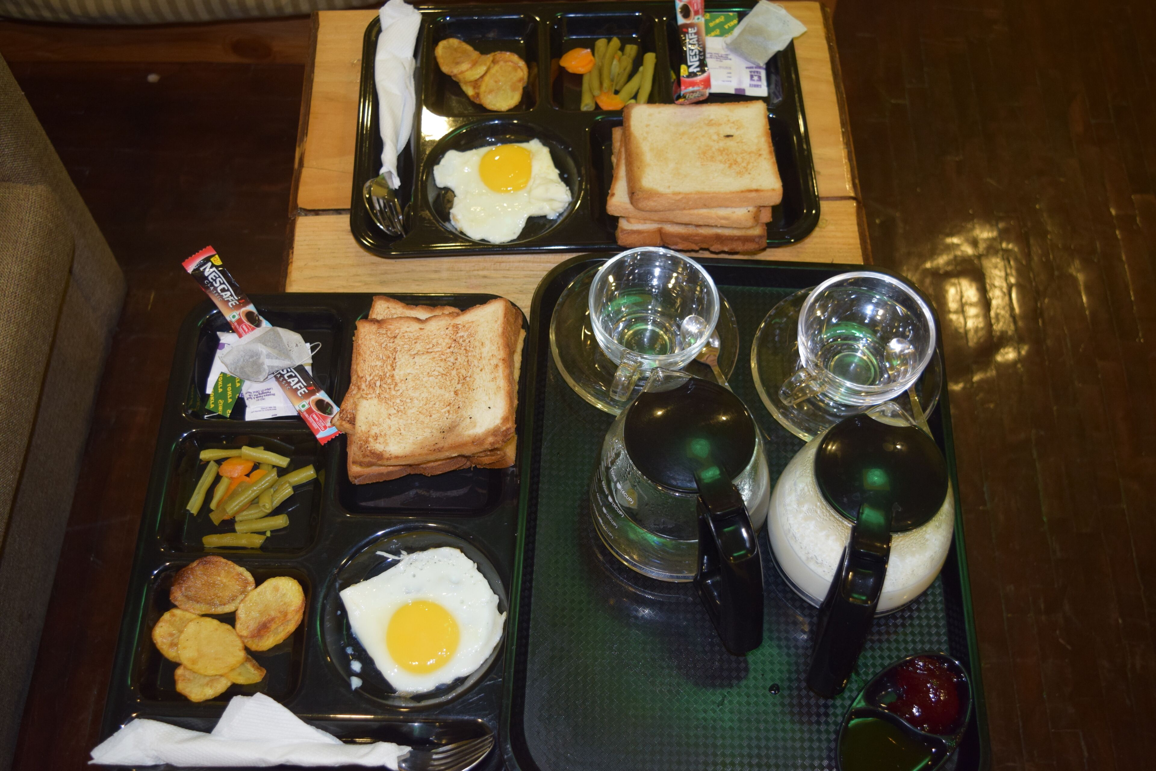 A breakfast tray with toast, eggs, and French fries.