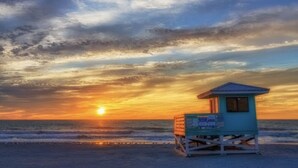 Une tour de surveillance des sauveteurs sur une plage au coucher du soleil.