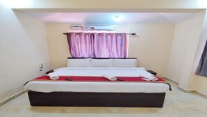 Quarto com cama, ventilador de teto, ar condicionado e cortina.