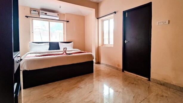 Quarto com cama, janela, porta e ar condicionado.
