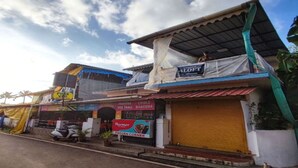 Vista da rua com um edifício que apresenta uma placa com 'ALOFT' e outra com 'FROZEN CORNER'.