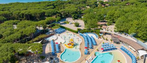 Un resort con varias piscinas, parque acuático y zona de playa con sombrillas.