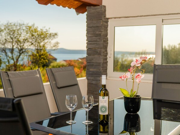 A table with two wine glasses, a bottle of wine, and a potted orchid. - Angels Retreat by Interhome (Maslenica)