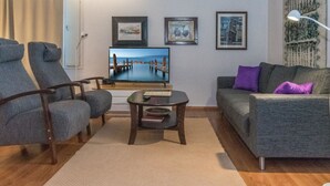A modern living room with a flat-screen TV, two armchairs, a sofa, and a coffee table. - Saariseläntie 8 b 7 by Interhome (Inari)