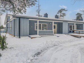 Un bâtiment d’un seul étage doté d’un porche et d’un espace extérieur abrité avec des sièges.