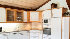 A kitchen with white cabinets, a microwave, an oven, and a sink. - Wiedersehen by Interhome (Saas-Grund)