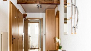 A hallway with wooden doors, a wooden cabinet, and a radiator. - Wiedersehen by Interhome (Saas-Grund)