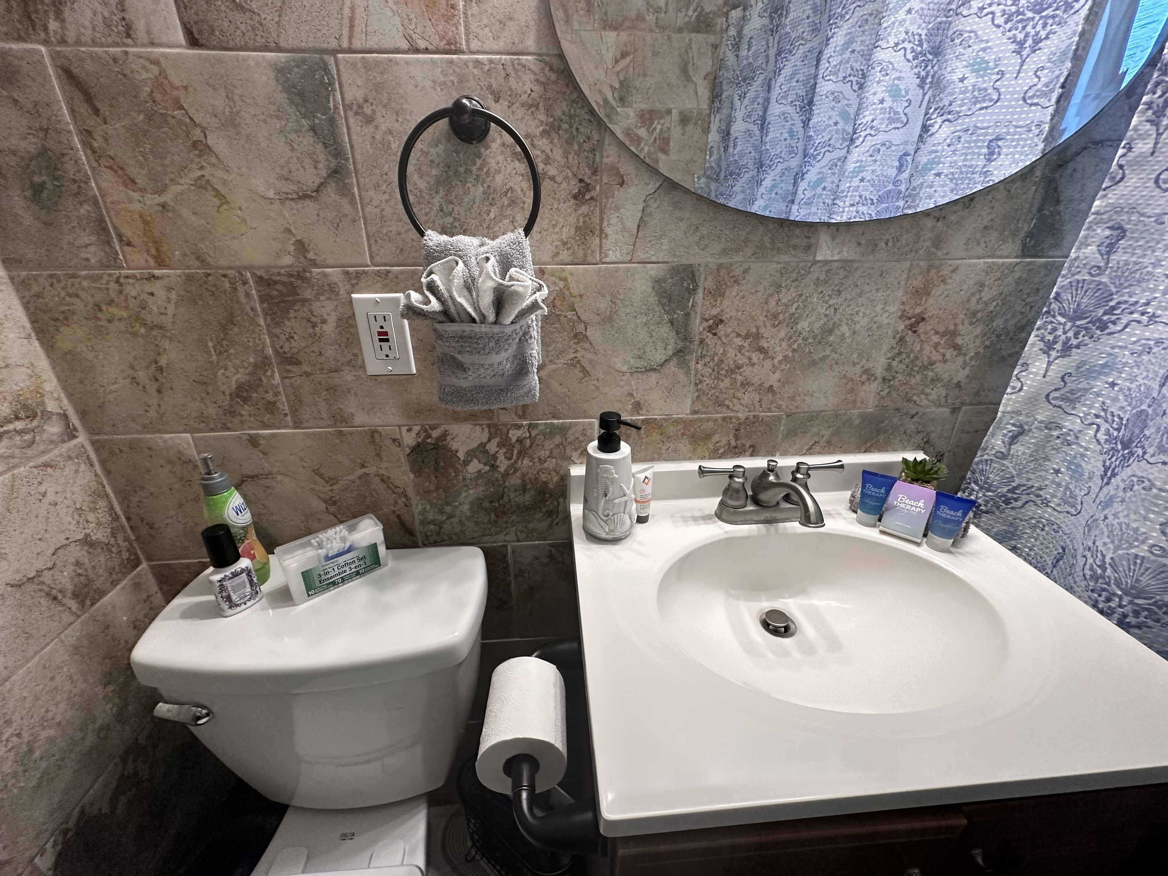 Une salle de bain équipée de toilettes, d’un lavabo et d’un porte-serviettes.