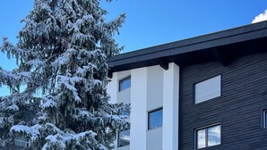 Ein modernes Gebäude mit einem schneebedeckten Baum davor.