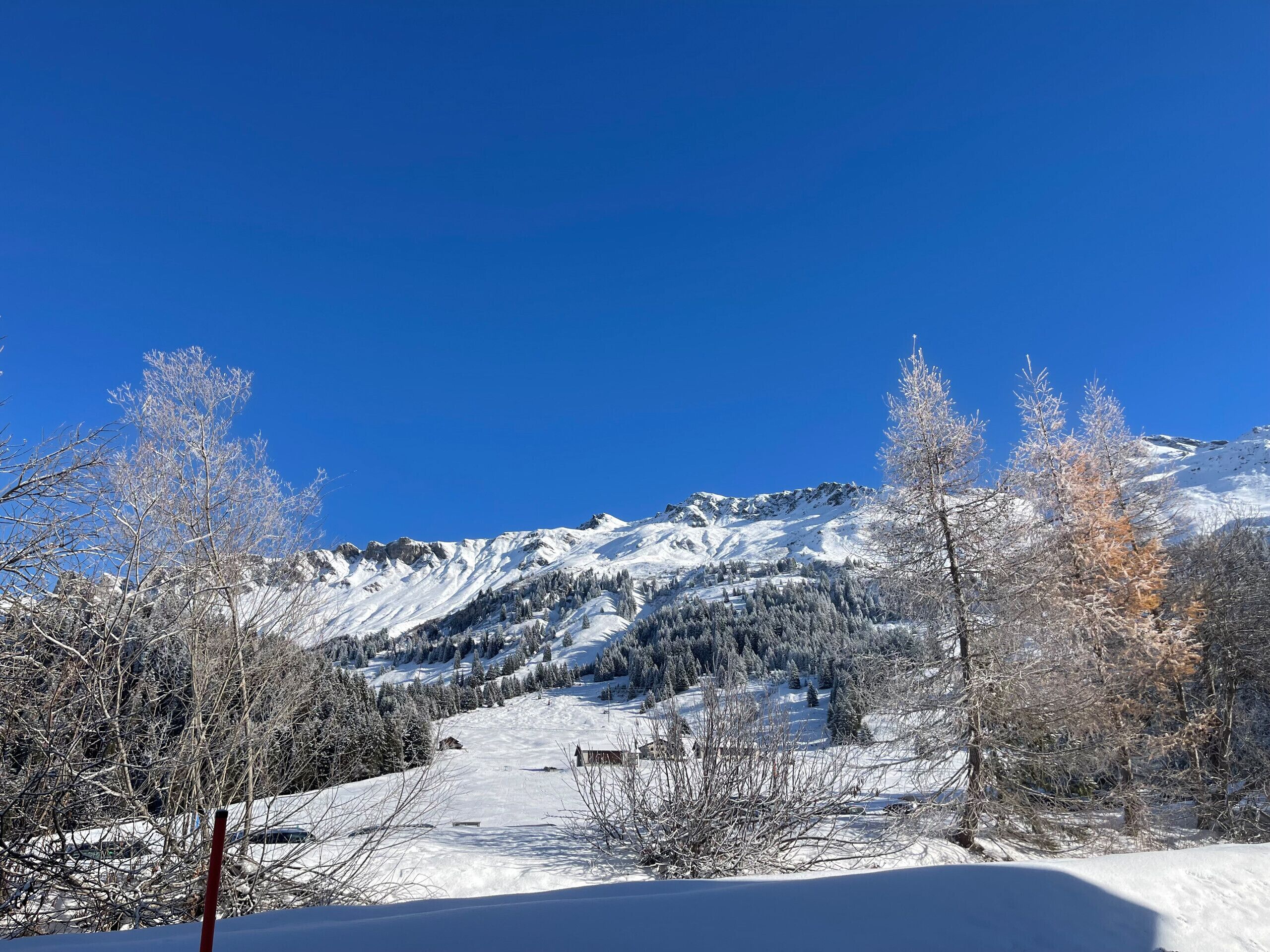 Paisatge de muntanya nevada amb cels blaus i nets.