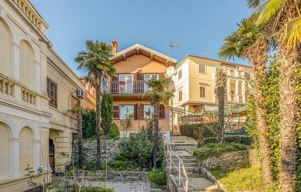A multi-story building with balconies, a stone staircase, and surrounding greenery. - Amazing home in Opatija with WiFi (Opatija)