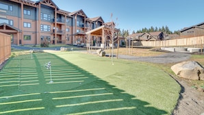 A residential complex with multiple apartment buildings, a well-maintained lawn, and a covered outdoor seating area. - Suncadia Resort Condo: Balcony & Golf Course Views (Cle Elum)