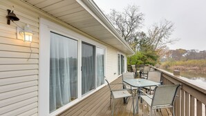 A covered deck with a table and chairs, overlooking a body of water. - Salem Vacation Home w/ Dock: Steps to Paddock Lake (Salem)