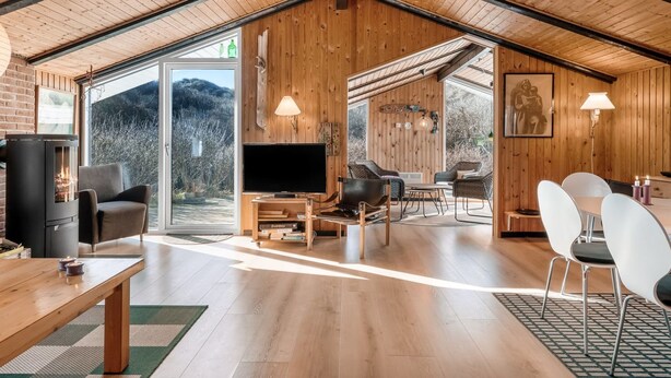 Un amplio salón con chimenea, televisor y mesa de comedor.