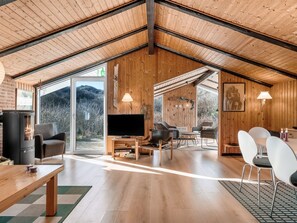 A spacious living area with a fireplace, a TV, and a dining table.