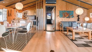 Un loft espacioso con techos altos, comedor, cocina y sala de estar con un gran tapete.
