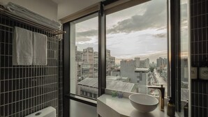 A modern bathroom with a large window, a toilet, and a sink with a bowl. - Hanns Summer (Taipei)