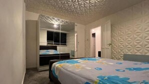 A bedroom with a bed, a wardrobe, and a mirror. - Charming 2bedroom Retreat in Great Barr/hamsted (Birmingham)