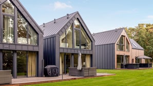 A modern house with large windows and a sloped roof.