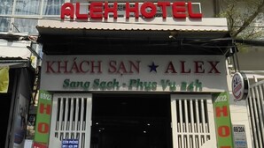 Entrada de un hotel con un letrero que dice "ALEX HOTEL" y "KHÁCH SAN ALEX".