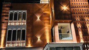 A modern building with large windows, a balcony, and a unique facade design. - THE LOVE PASSION KARMA CLUB & RESORT (Udaipur)
