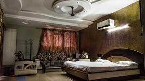 Une chambre à coucher avec un lit, un canapé, un radiateur et un ventilateur de plafond.