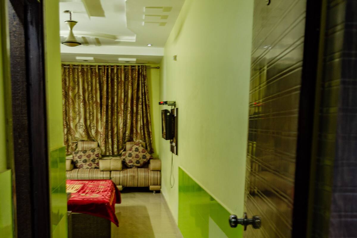 A narrow hallway with a sofa set and a red blanket in the background.