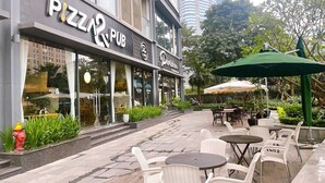 A pizza pub with outdoor seating and a fire hydrant. - Vinhome Skylake Luxury Apartment  (Hanoi)