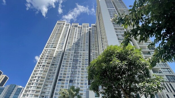 A high-rise building with multiple floors, surrounded by greenery and other buildings. - Vinhome Skylake Luxury Apartment  (Hanoi)
