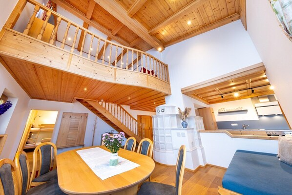 Cozy retreat with a dining area, kitchenette, and staircase leading to an upper level.