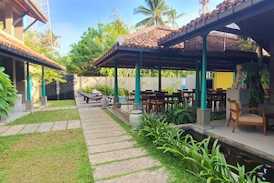 Un patio con mobiliario exterior, una piscina pequeña y abundante vegetación.