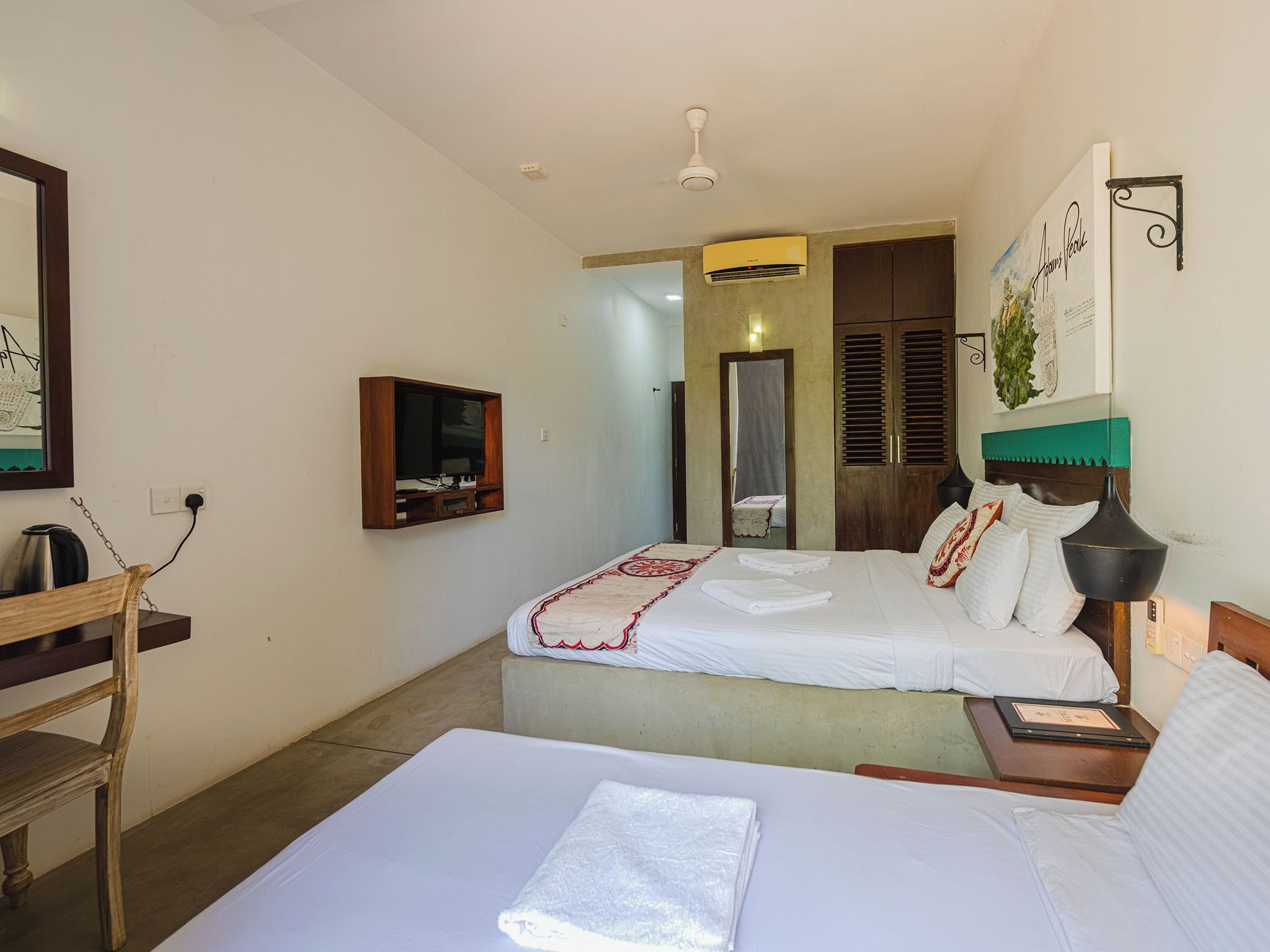 Una habitación de hotel con cama, escritorio, silla, televisión y un cuadro en la pared.