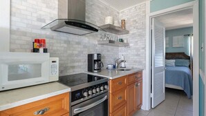 A compact kitchen with a microwave, stove, oven, and coffee maker. There are cabinets and a countertop. - Beachside Breeze 1BR Condo with Pool & Great View! (Wildwood Crest)
