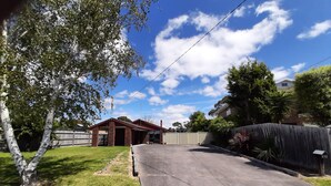 A residential driveway leading to a brick house with a covered porch. - Safety Beach Home - Walking distance to the beach and close to all amenities (Safety Beach)