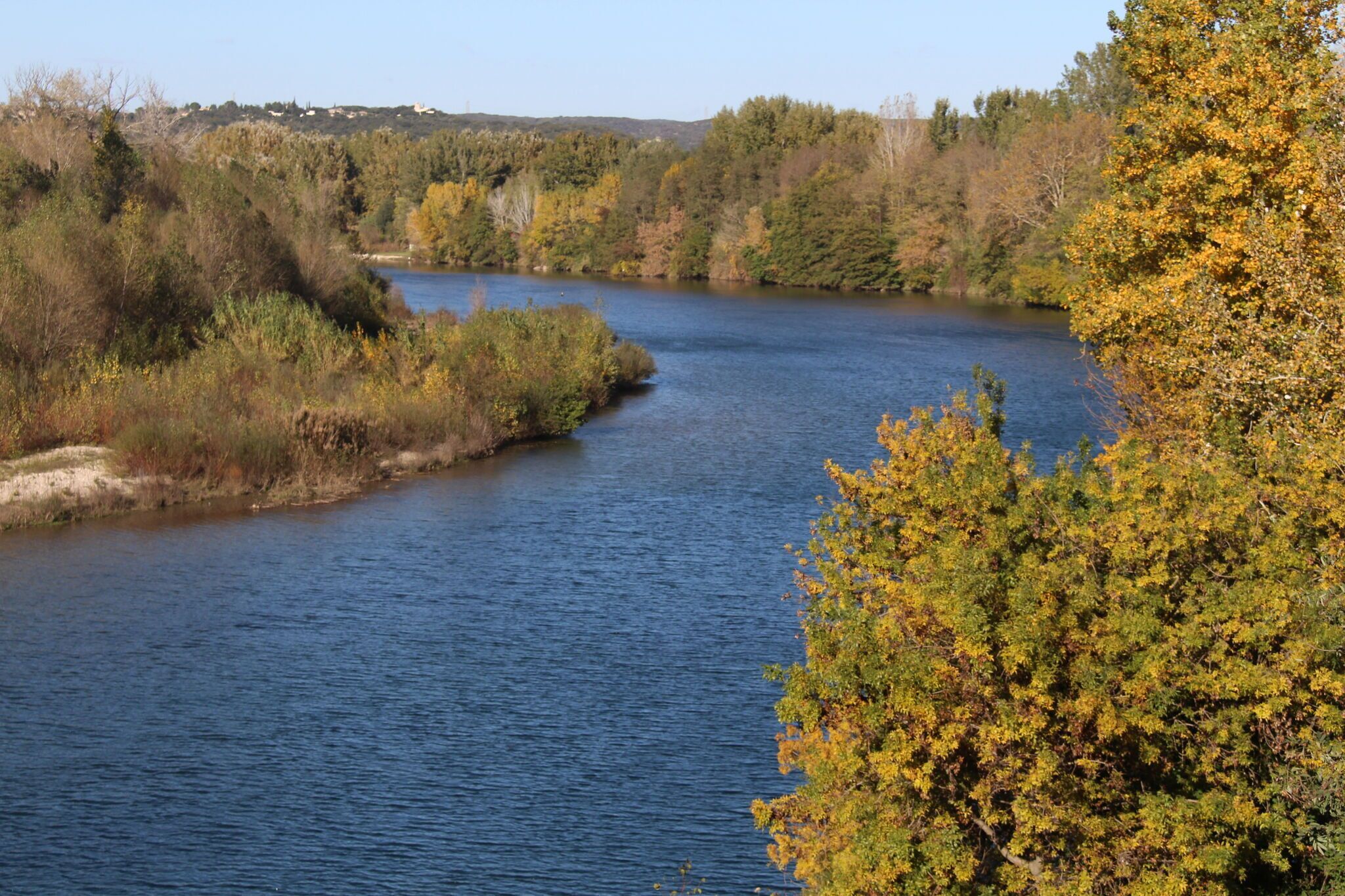 A river surrounded by trees with autumn foliage.