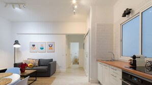 A modern kitchen with white cabinets, a wooden countertop, and a built-in oven.