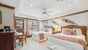 A hotel room with two beds, a desk, a chair, a ceiling fan, and a window with curtains. - Lodge Tower 686 2BR at the base of Vail Mountain (Vail)