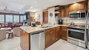 A modern kitchen with wooden cabinets, stainless steel appliances, and a built-in dishwasher. - Lodge Tower 686 2BR at the base of Vail Mountain (Vail)