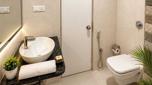 Moderni kylpyhuone, jossa on valkoinen pesuallas, wc ja suihku.