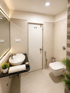 Un baño moderno con un lavabo blanco, inodoro y ducha.